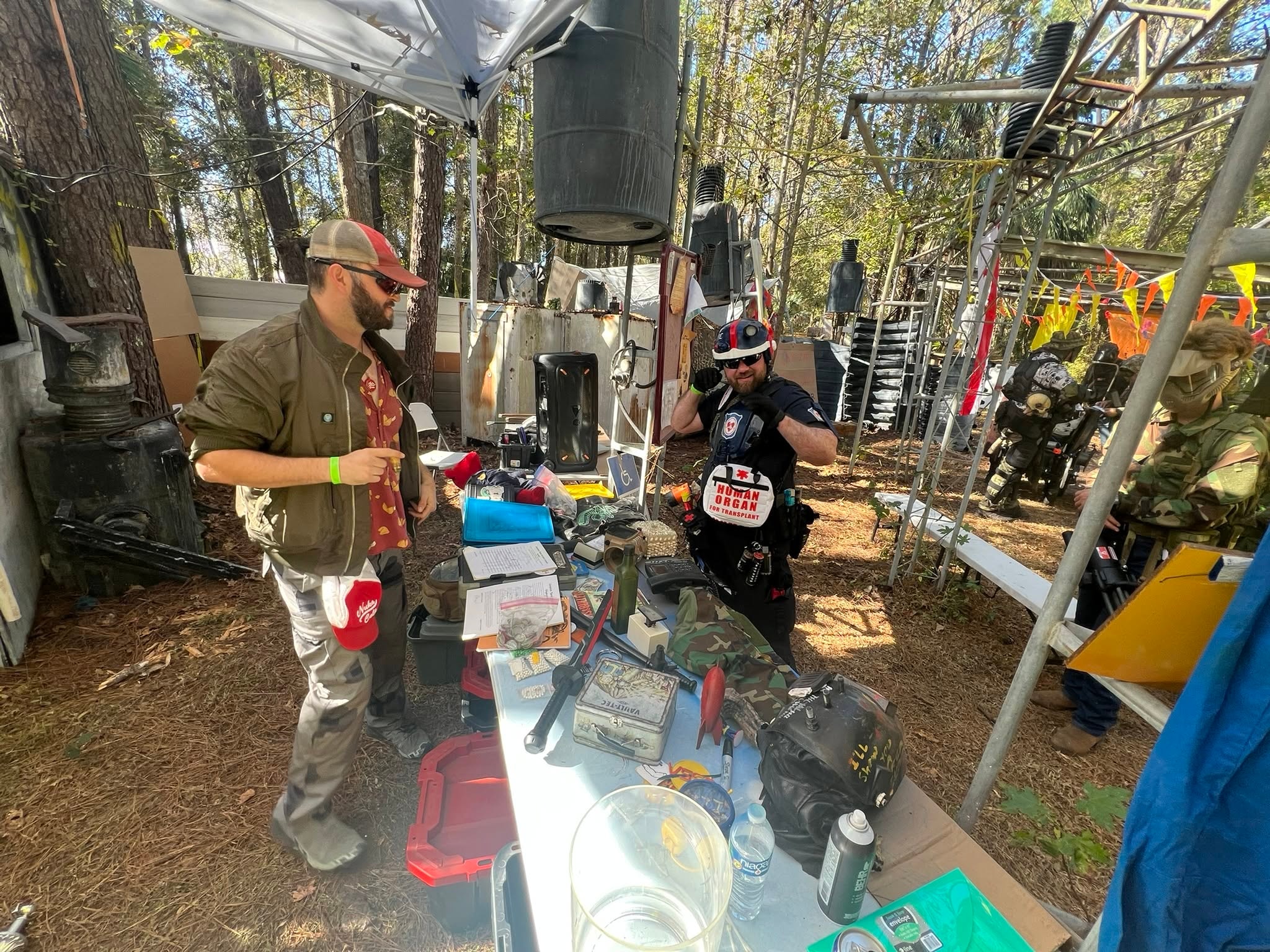 Sunshine Band merchant caravan table loaded with wasteland goods at a MindGame Productions event